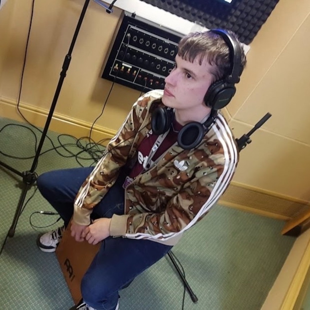 Music technology student Alex Pavey, wearing headphones in the music studio