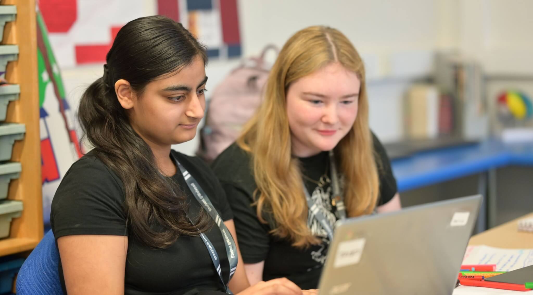 Two students working at a laptop